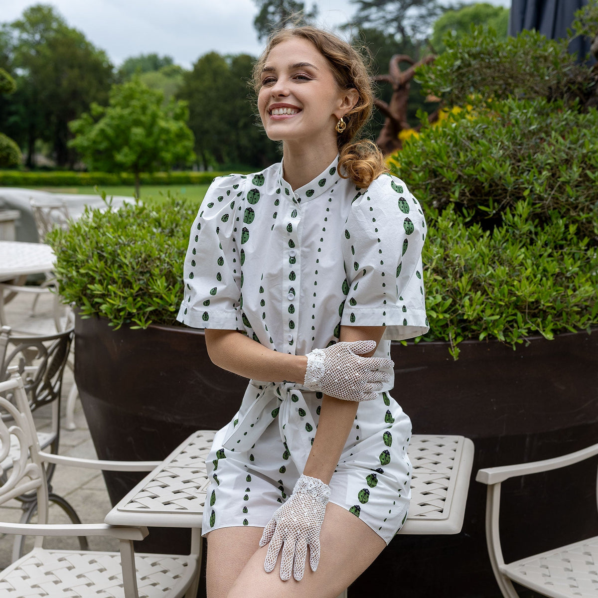Woman wearing cotton crochet gloves in ecru sitting outdoors