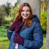 Woman wearing knitted gloves in burgundy with a snood and coat on a walk