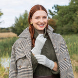 Woman wearing leather gloves in silver whilst on a walk in the woodlands