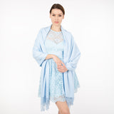 Woman wearing plain pashmina shawl in pale blue- draped over her shoulders