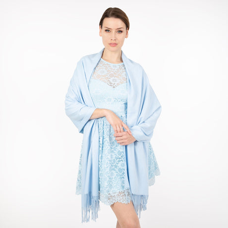 Woman wearing plain pashmina shawl in pale blue- draped over her shoulders