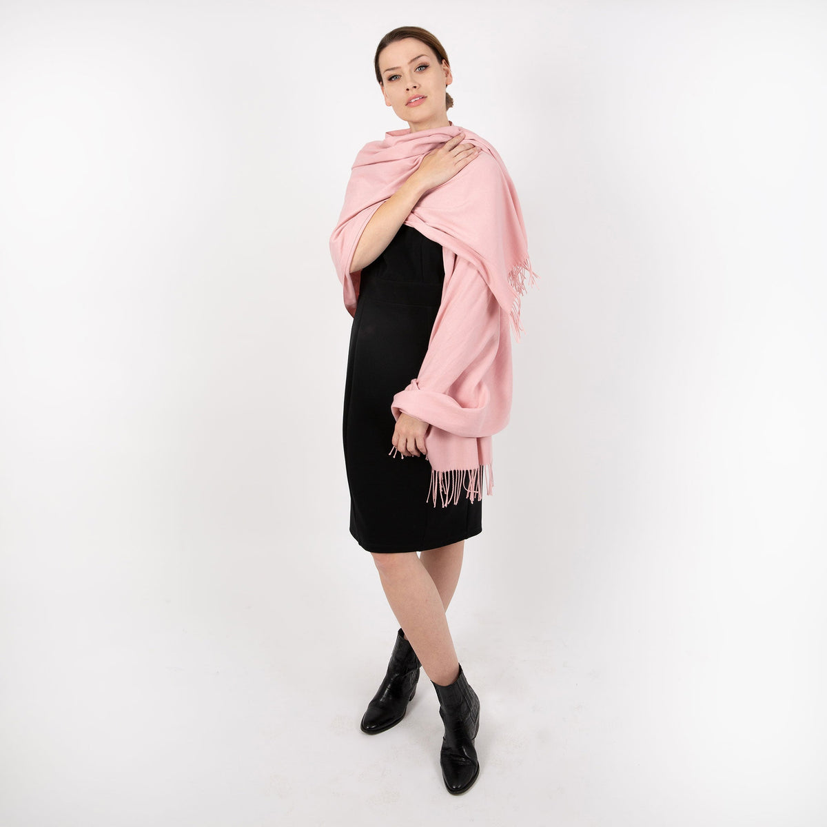 Woman wearing plain pashmina in pale pink, full length. 