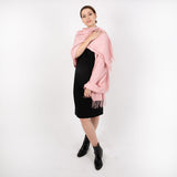 Woman wearing plain pashmina in pale pink, full length. 