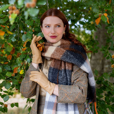 woman wearing silk-lined leather gloves in toffee walking around the woodlands